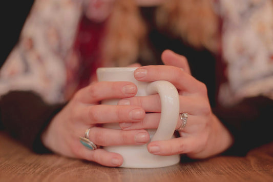 Death Doula holding a coffee mug