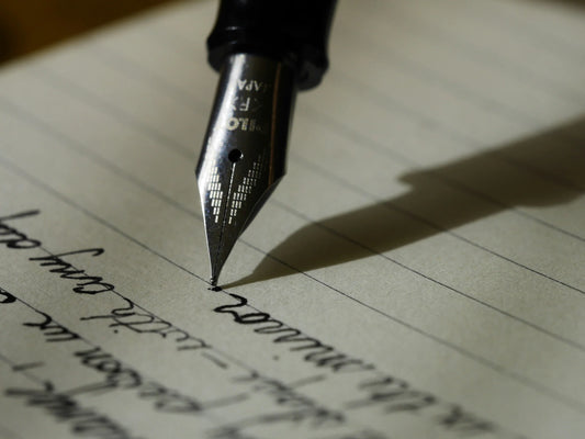 Someone using an ink pen to write a eulogy