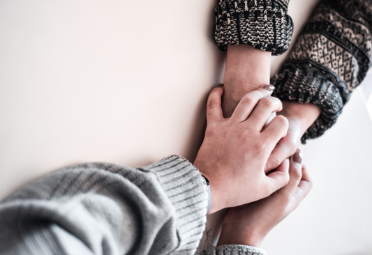 Hands holding symbolizing choosing an urn for your mom