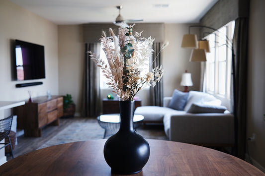 Black vase urn on a table with dried foliage