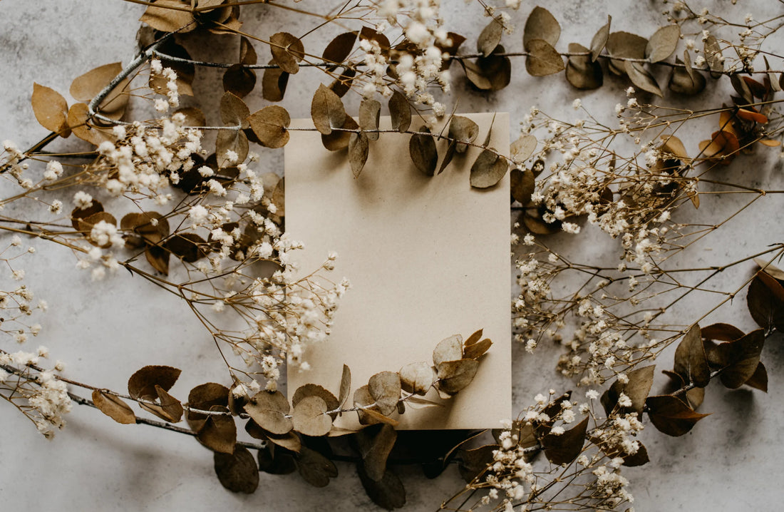 Gift box with an urn in it surrounded by eucalyptus and baby's breath